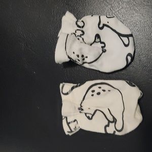 White infant mittens with black outline of an animal.